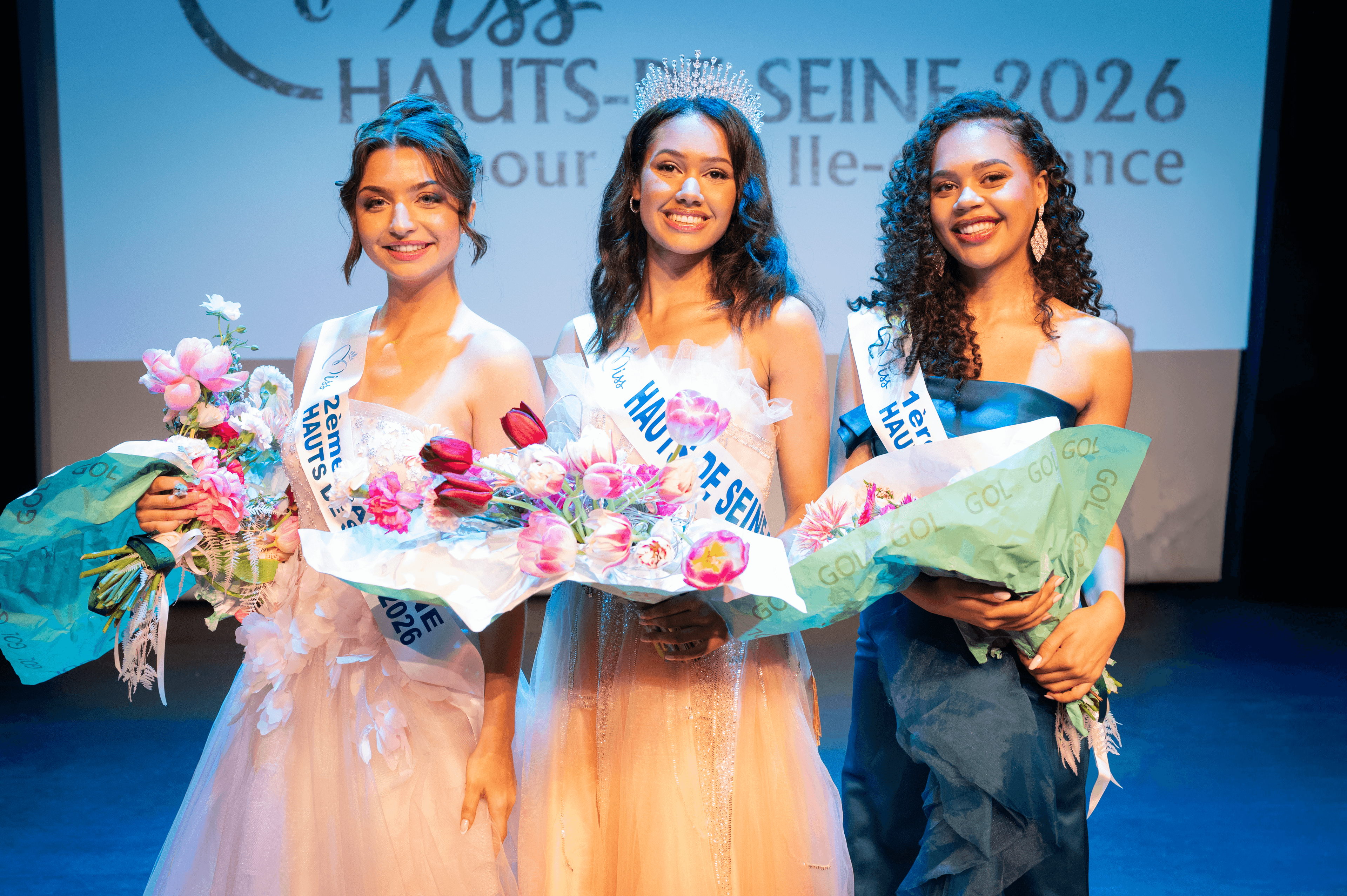 Janisse sur scène avec son bouquet de fleurs, entourée des 1ère et 2ème dauphines